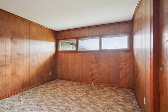 carpeted spare room with wood walls