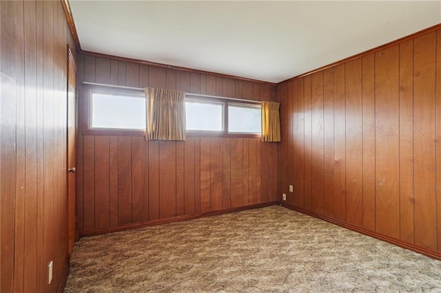 carpeted spare room with wood walls