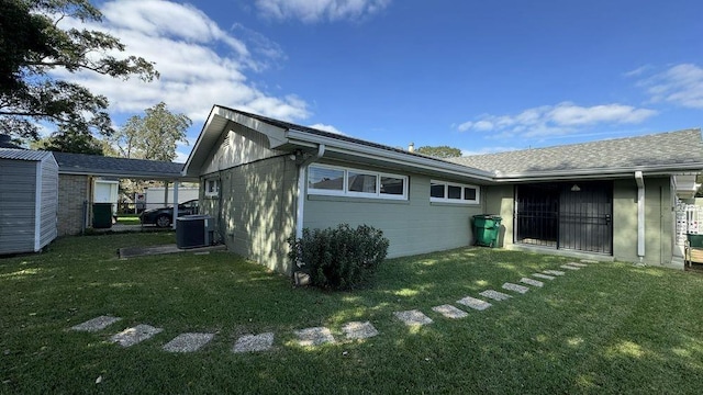 rear view of property featuring central AC unit and a yard