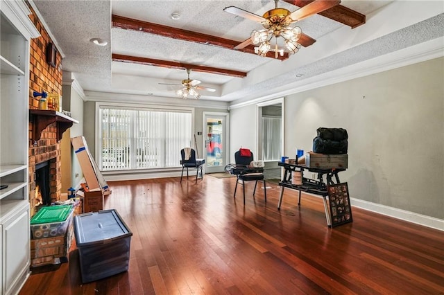 interior space featuring wood-type flooring, a textured ceiling, a brick fireplace, and ceiling fan