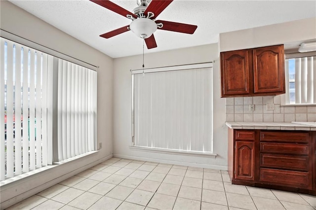 kitchen with light tile patterned floors, tasteful backsplash, and ceiling fan