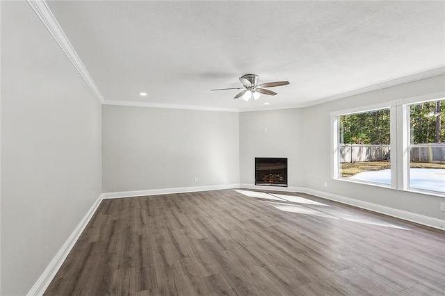 unfurnished living room featuring ceiling fan, dark wood-type flooring, and ornamental molding