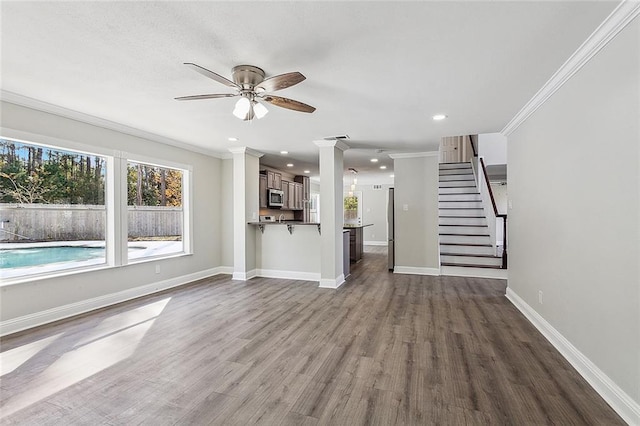 unfurnished living room featuring dark hardwood / wood-style floors, ceiling fan, and crown molding