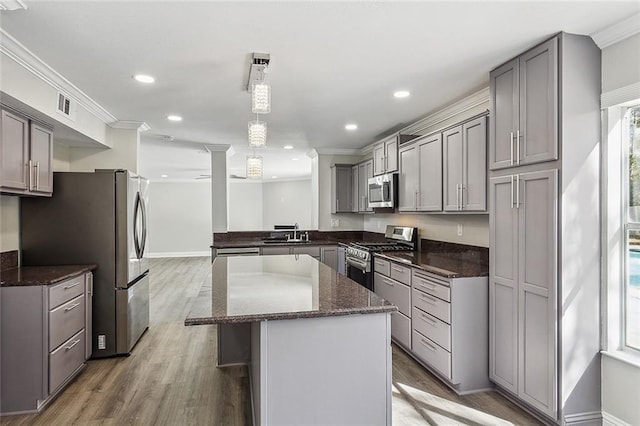 kitchen featuring appliances with stainless steel finishes, crown molding, sink, decorative light fixtures, and gray cabinets