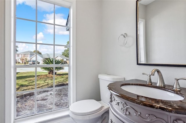 bathroom featuring a wealth of natural light, vanity, and toilet