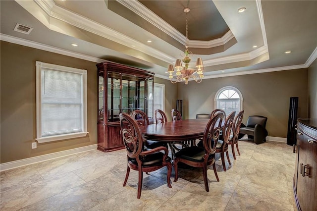 dining room featuring a raised ceiling, crown molding, and an inviting chandelier