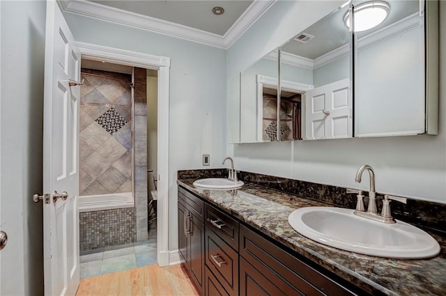 bathroom with crown molding, hardwood / wood-style floors, and vanity