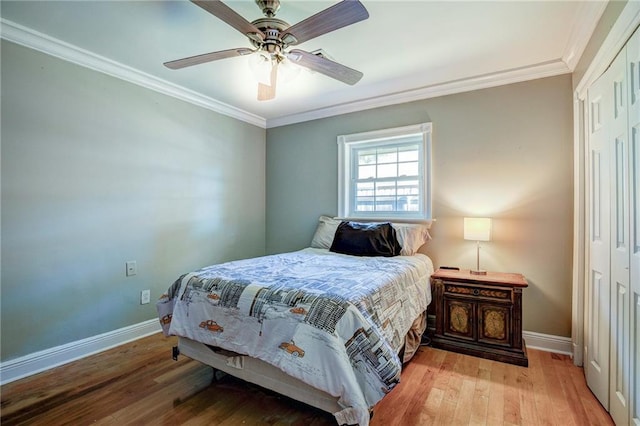 bedroom featuring light wood-type flooring, a closet, ceiling fan, and crown molding