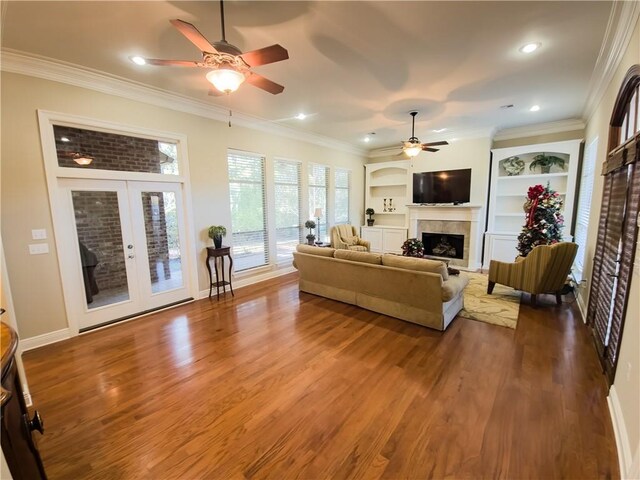 living room with crown molding, a fireplace, hardwood / wood-style floors, and french doors