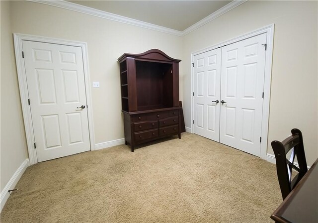 bedroom with light colored carpet, crown molding, and a closet