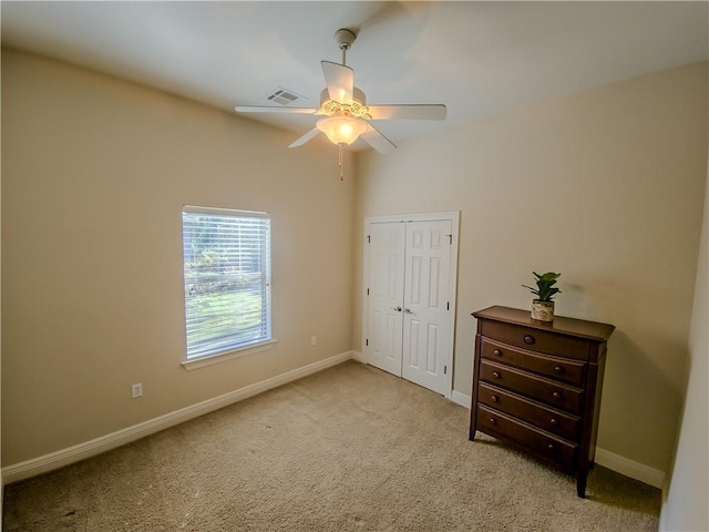 unfurnished bedroom featuring ceiling fan, a closet, and light carpet