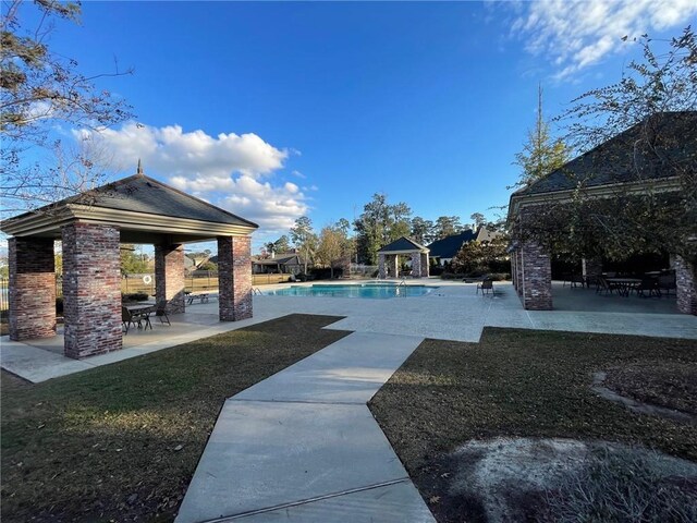 rear view of property featuring ceiling fan and a patio