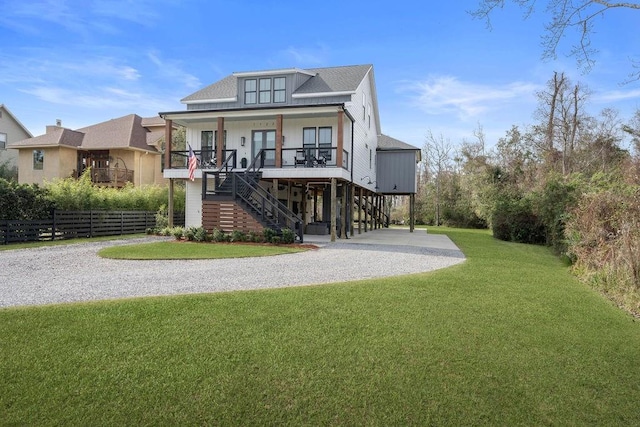 rear view of house featuring a porch and a lawn