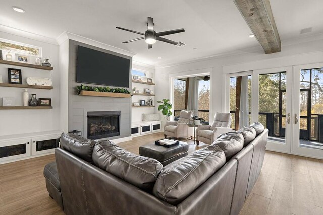 living room featuring crown molding, beam ceiling, light hardwood / wood-style flooring, and french doors