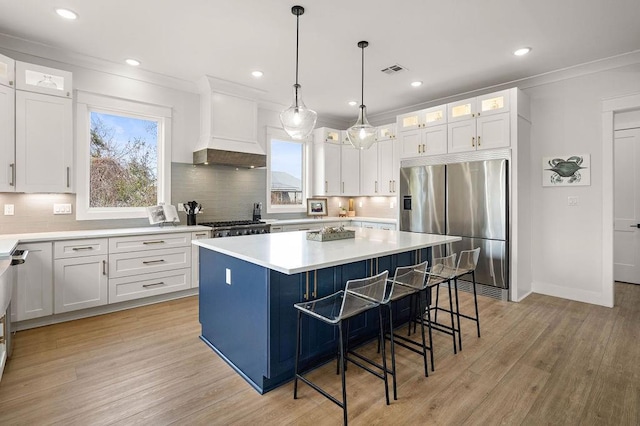 kitchen with premium range hood, a center island, white cabinets, and stainless steel fridge with ice dispenser