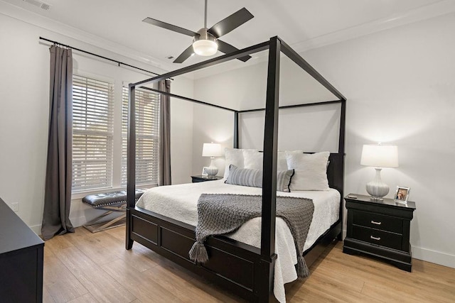 bedroom featuring ornamental molding, light wood-type flooring, and ceiling fan