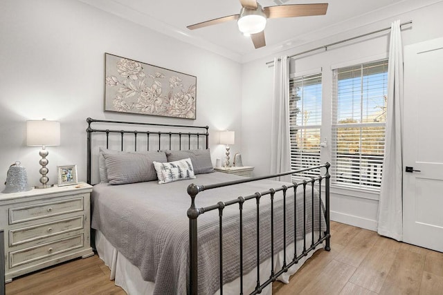 bedroom with ornamental molding, light wood-type flooring, and ceiling fan