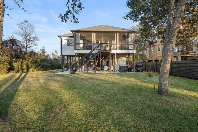 back of property with a sunroom and a yard