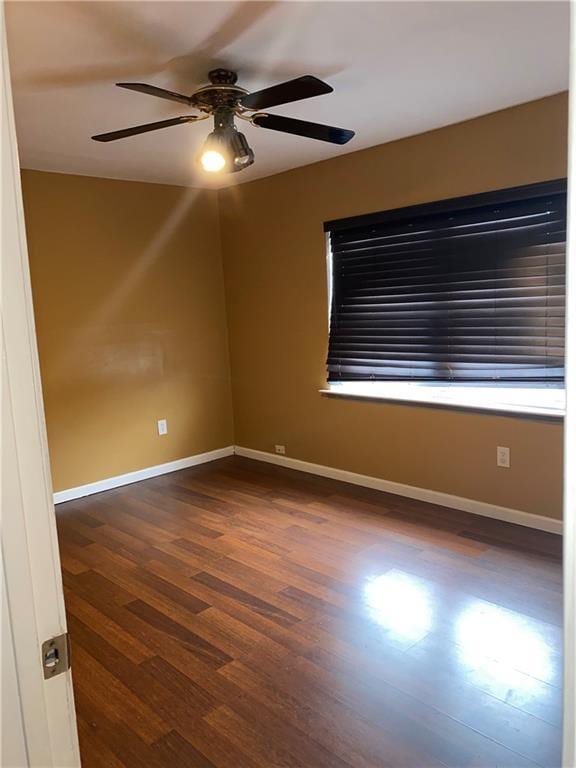 spare room featuring ceiling fan and dark wood-type flooring