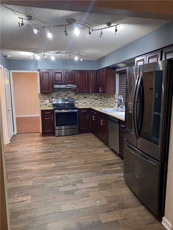 kitchen with decorative backsplash, stainless steel appliances, light hardwood / wood-style floors, and sink