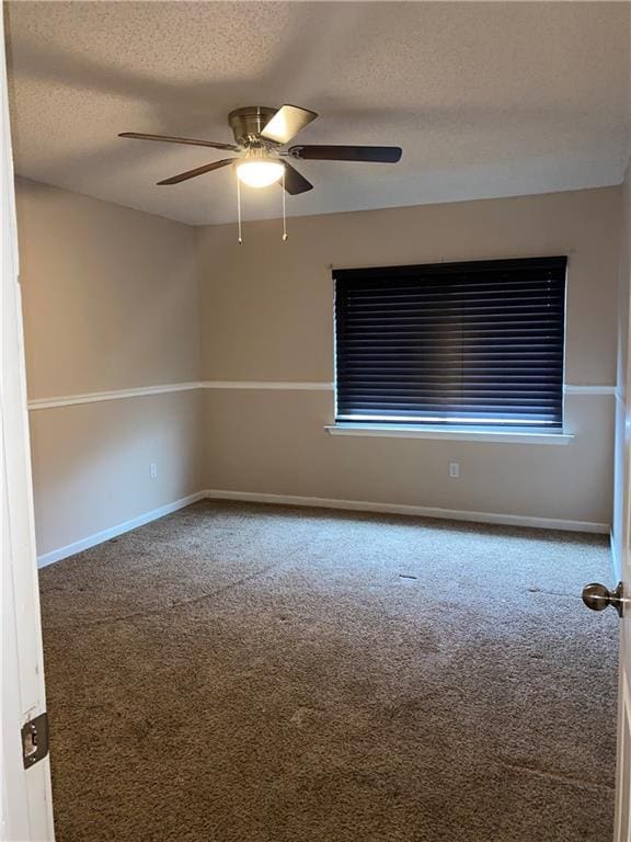 spare room featuring carpet flooring, a textured ceiling, and ceiling fan