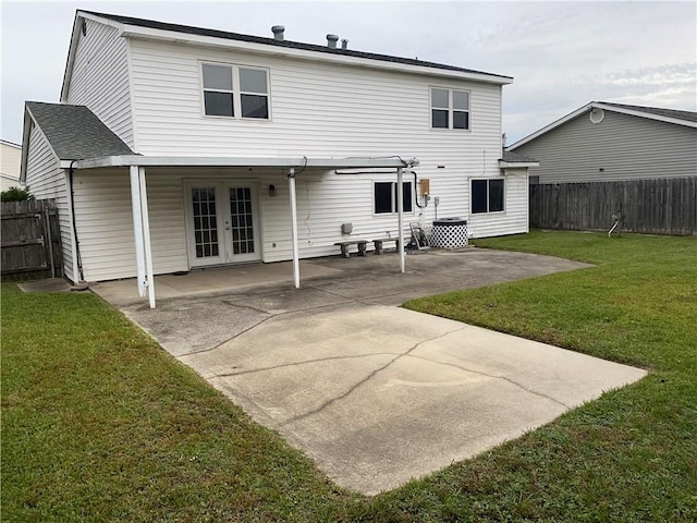 back of property with french doors, a patio, and a yard