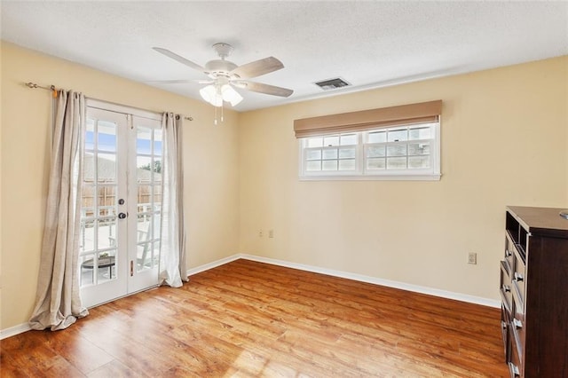 unfurnished room with french doors, light wood-type flooring, and ceiling fan