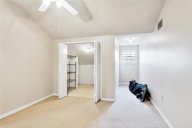 carpeted bedroom featuring ceiling fan, a textured ceiling, and vaulted ceiling