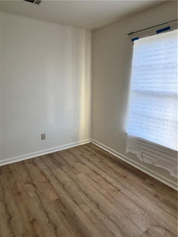 empty room with wood finished floors and baseboards