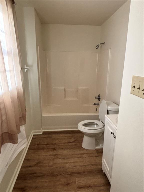 bathroom with toilet, tub / shower combination, wood finished floors, and vanity