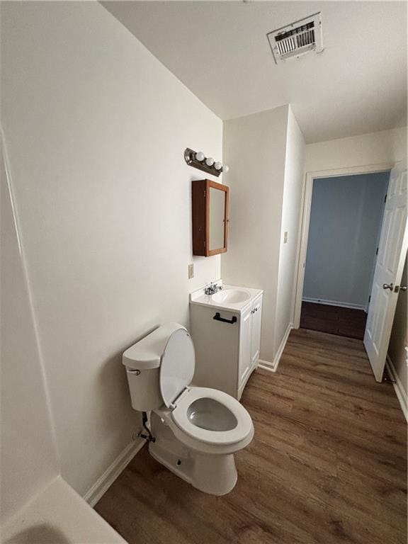 bathroom with wood-type flooring, vanity, and toilet