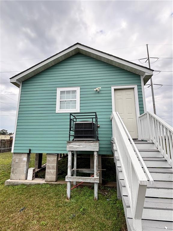 rear view of house with a yard and fence