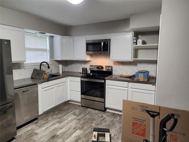 kitchen with white cabinets, decorative backsplash, sink, and appliances with stainless steel finishes