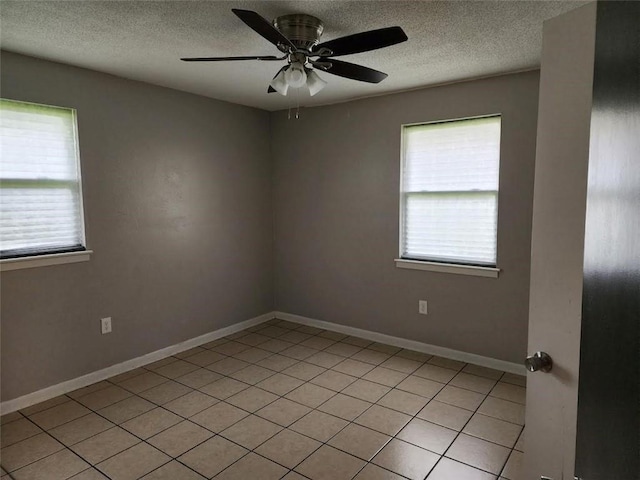 unfurnished room with light tile patterned floors, a textured ceiling, plenty of natural light, and ceiling fan