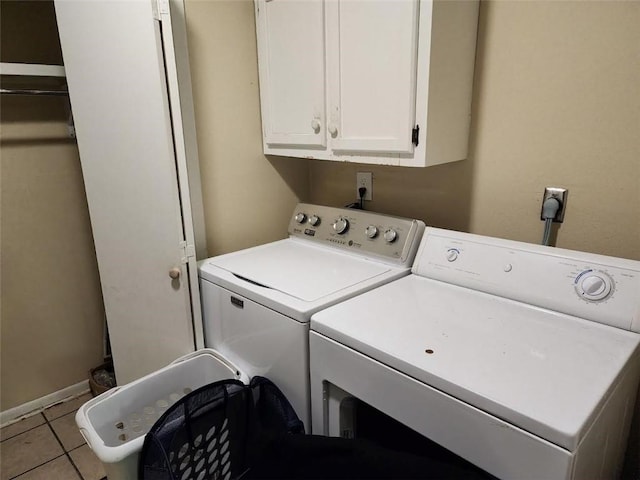 clothes washing area featuring cabinets, independent washer and dryer, and light tile patterned flooring