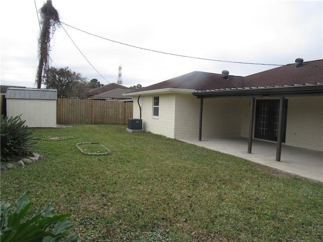 view of yard with central AC unit, a storage unit, and a patio area