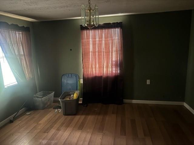 spare room featuring a chandelier and hardwood / wood-style flooring