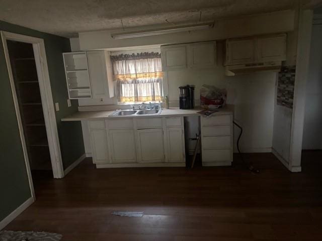 kitchen with white cabinets, dark wood-type flooring, and sink