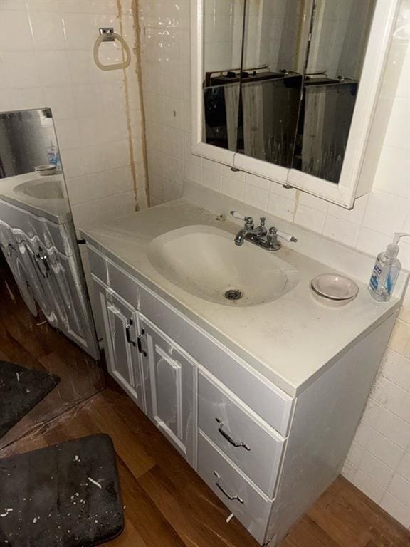 bathroom featuring vanity, hardwood / wood-style floors, and backsplash