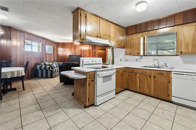 kitchen featuring plenty of natural light, kitchen peninsula, sink, and white appliances