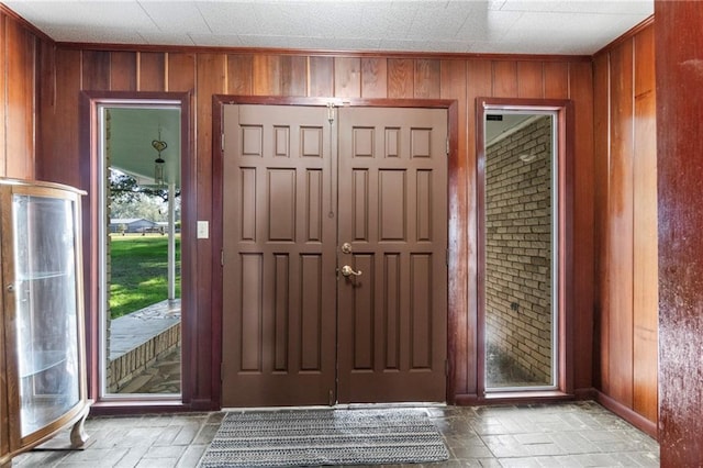 entrance foyer featuring plenty of natural light and wood walls