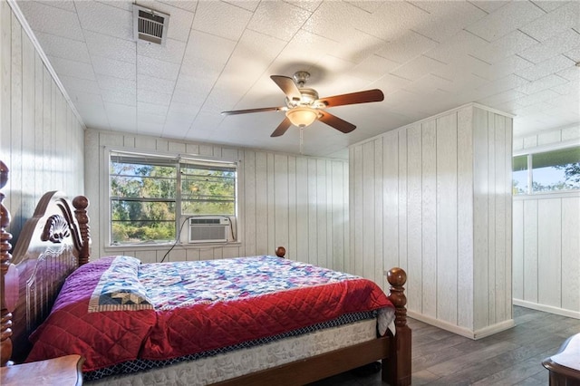 bedroom featuring wood-type flooring, ceiling fan, cooling unit, and wood walls