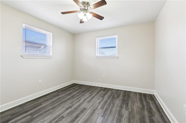 spare room with dark hardwood / wood-style flooring, a wealth of natural light, and ceiling fan