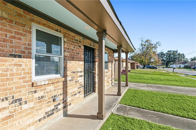 property entrance with a porch and a lawn