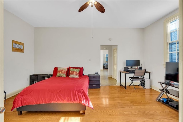 bedroom featuring light wood-style floors, baseboards, and ceiling fan