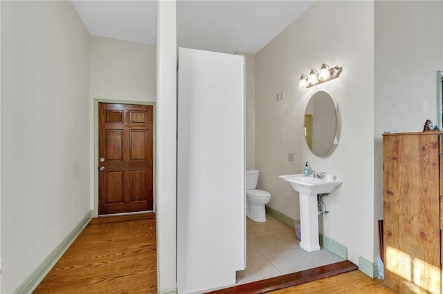 bathroom with hardwood / wood-style floors, toilet, and sink