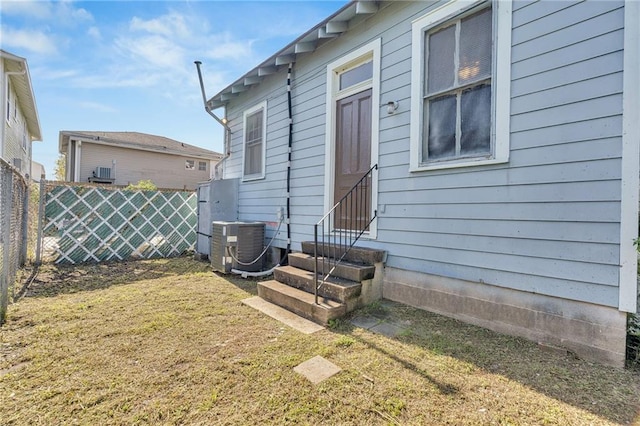 back of house with central AC and a lawn