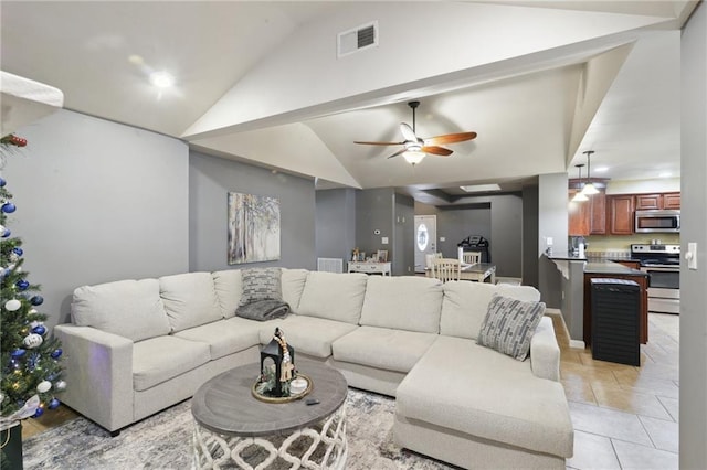 living room with light tile patterned floors, vaulted ceiling, and ceiling fan