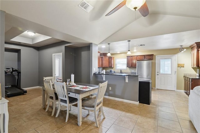 tiled dining area with vaulted ceiling and ceiling fan