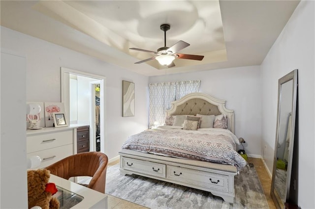 bedroom featuring ceiling fan and a raised ceiling